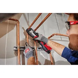 Image of the Milwaukee 1-1/8" ZoomLock MAX Press Jaw being used by a worker with an M12 FORCE LOGIC Press Tool on a copper pipe