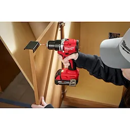  Worker using the Compact Brushless 1/2" Drill/Driver to screw in a cabinet handle