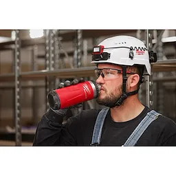 Image of a worker drinking from a Milwaukee PACKOUT Insulated Bottle with Chug Lid in black