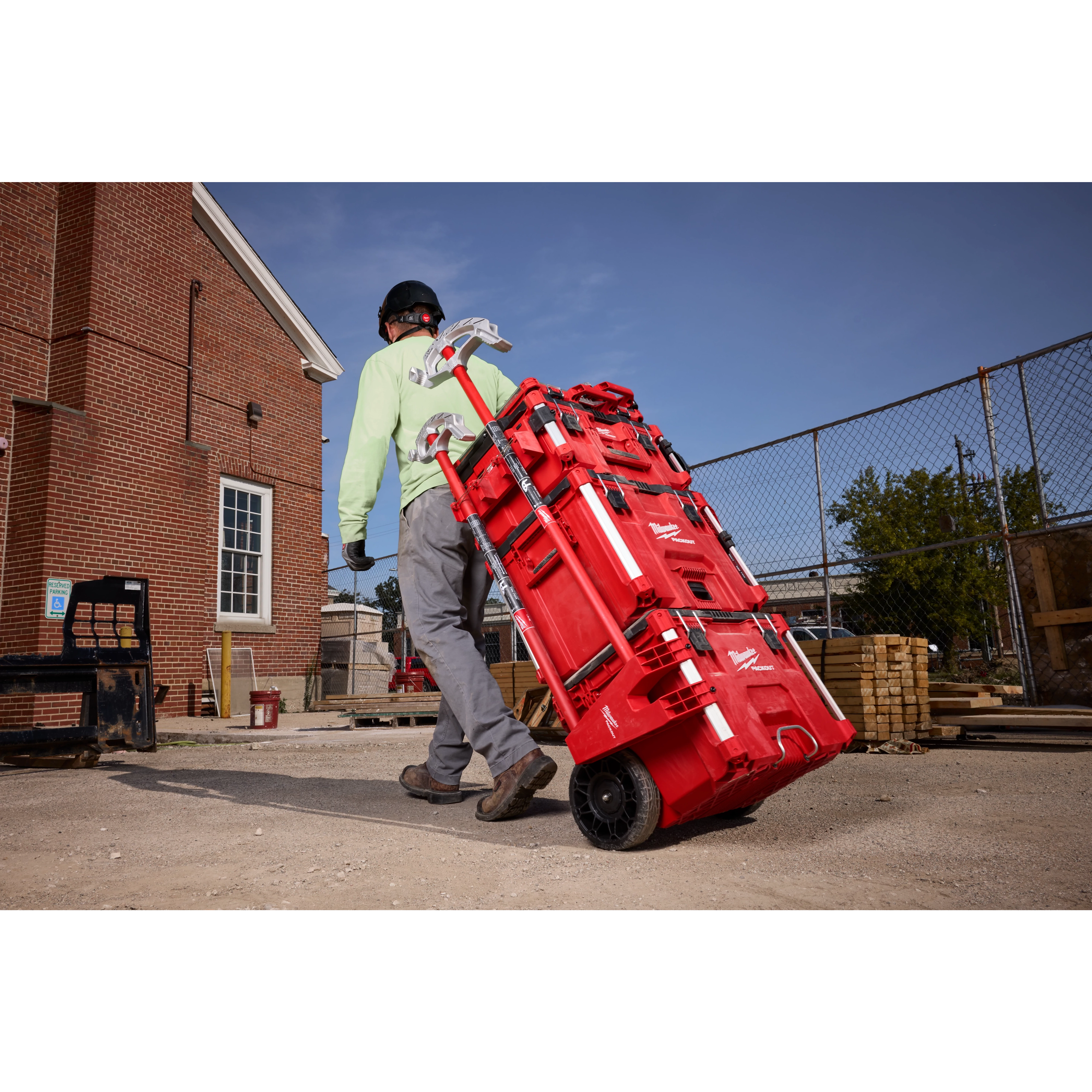 A person is pulling a PACKOUT Tool Box with a Long Tool Holder Attachment