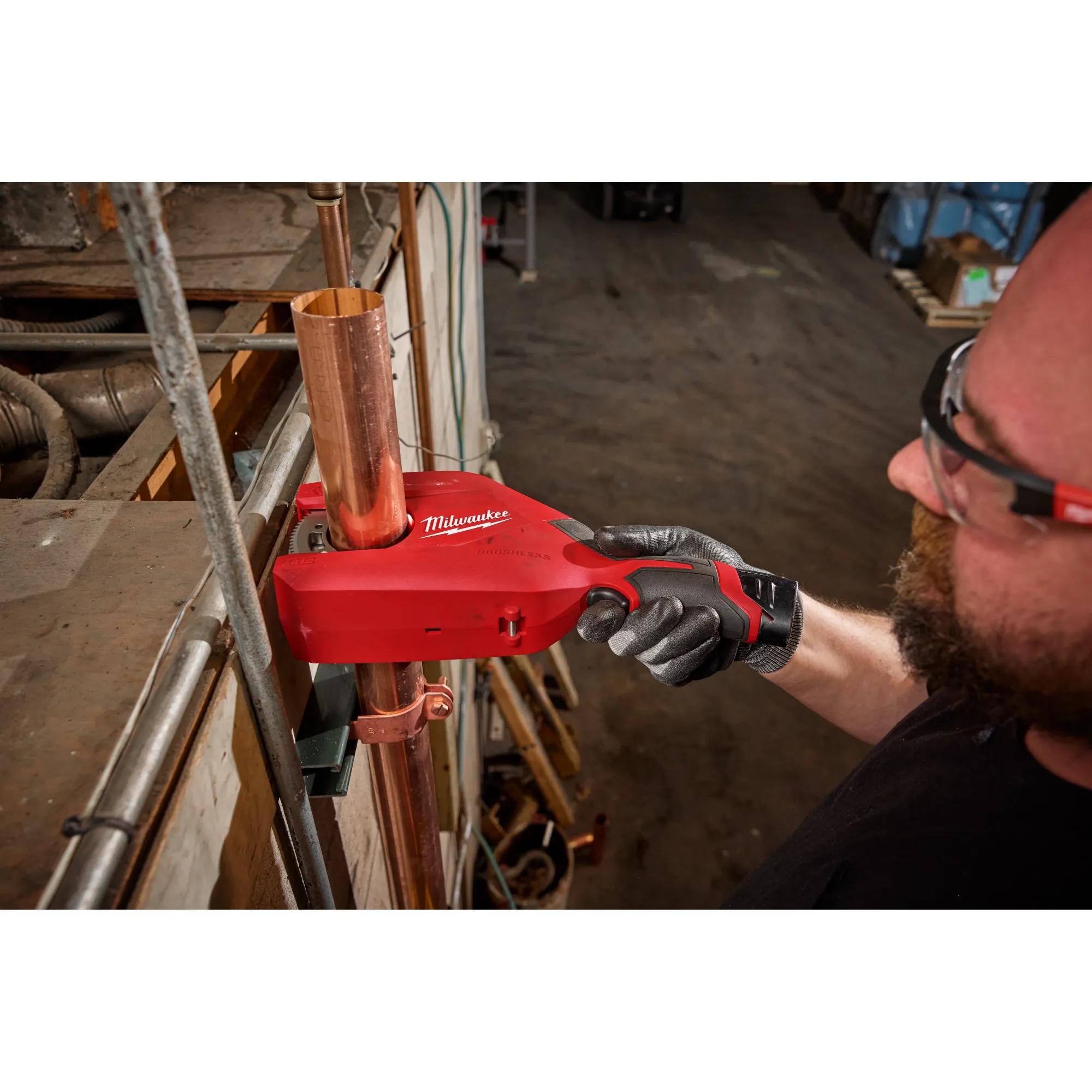 Image of the Milwaukee M12 Brushless 1-1/4" - 2" Copper Tubing Cutter being used by a worker on a jobsite to cut copper pipe