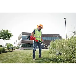 Image of a worker using the Milwaukee M18 FUEL 17” Dual Battery String Trimmer