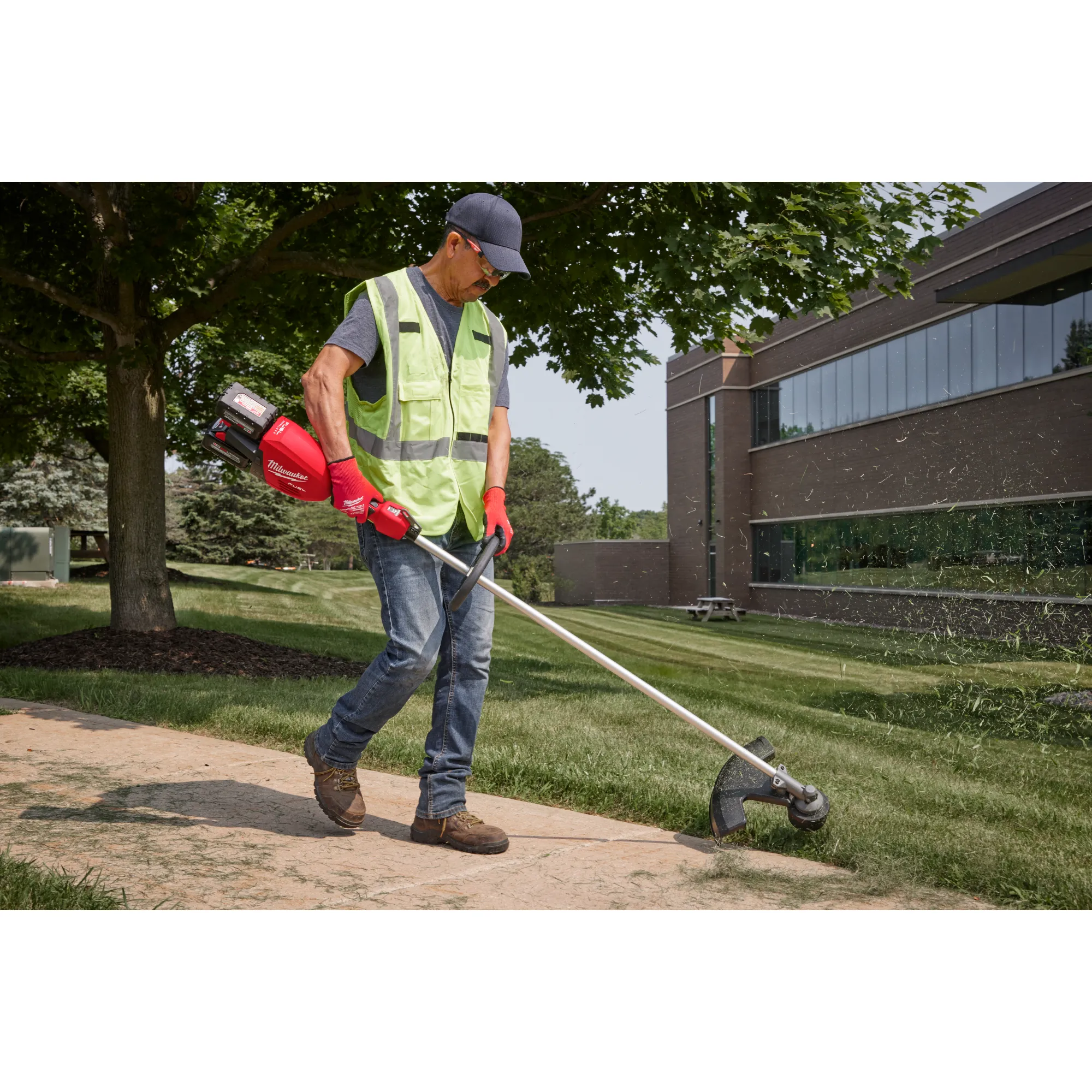 Image of a worker using the Milwaukee M18 FUEL 17” Dual Battery String Trimmer