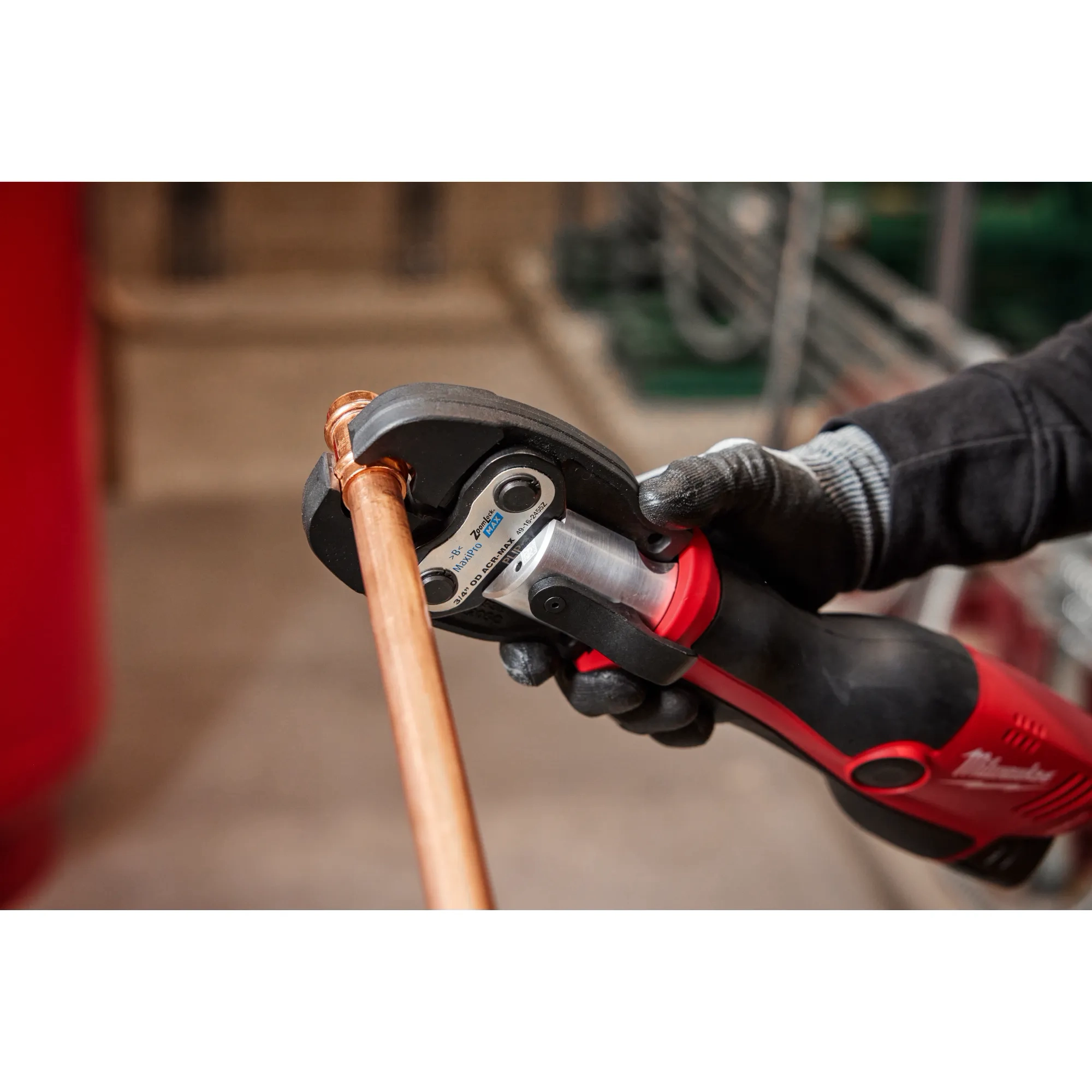 Image of the Milwaukee 1-1/8" ZoomLock MAX Press Jaw being used by a worker with an M12 FORCE LOGIC Press Tool on a copper pipe